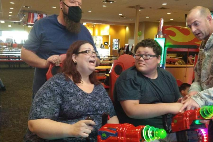 A woman and two men playing video games.