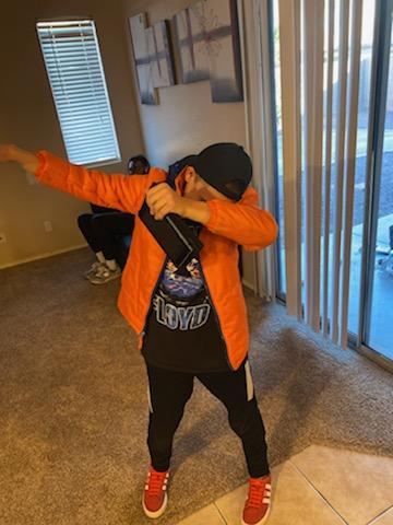 A person in an orange jacket and black hat