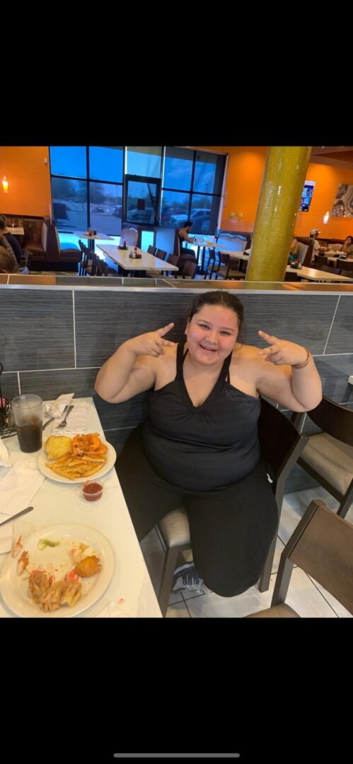 A woman sitting at a table with food.