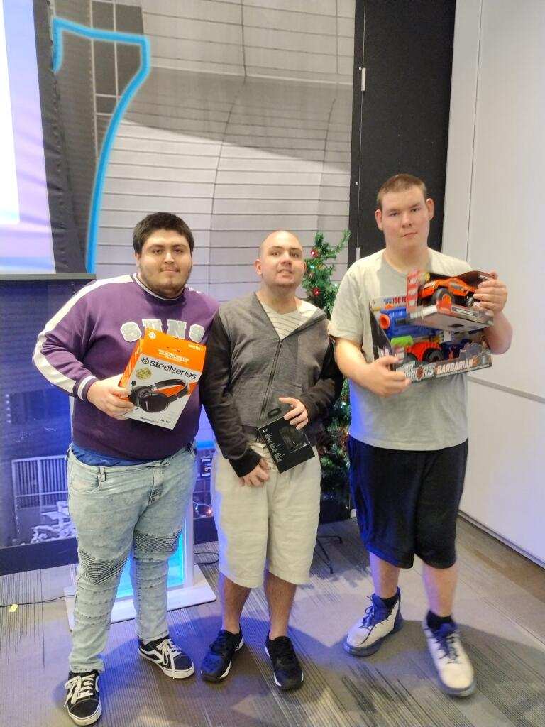 Three men standing next to each other holding books.