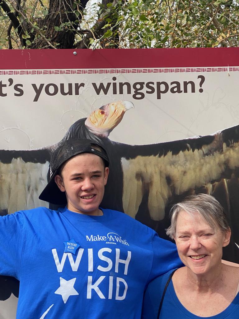 A man and woman posing for a picture in front of a sign.