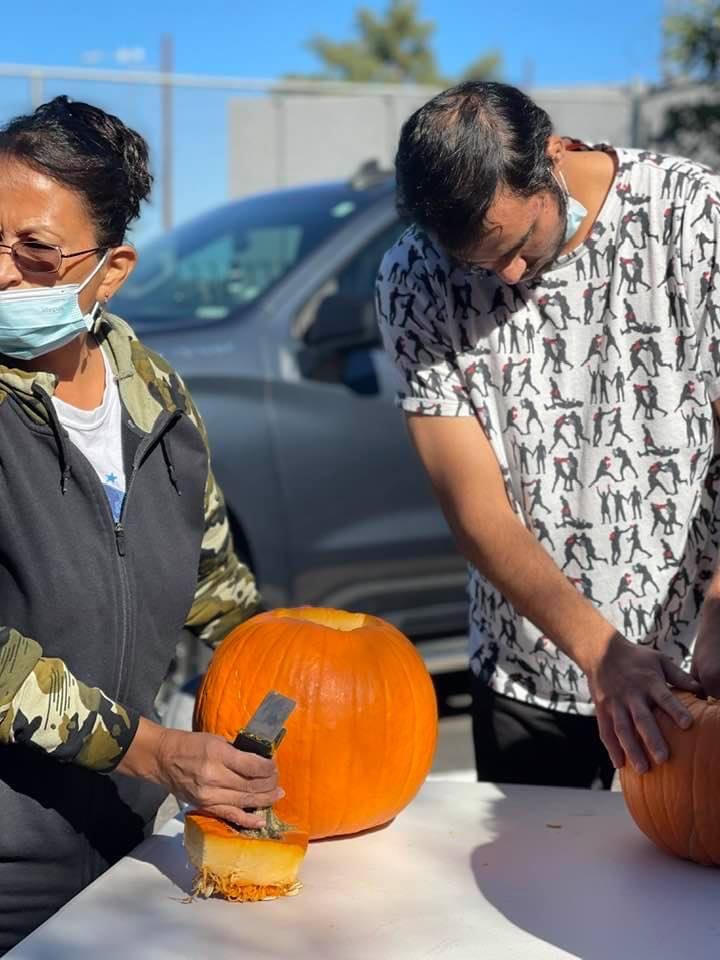 A group of people carving pumpkins on the street.