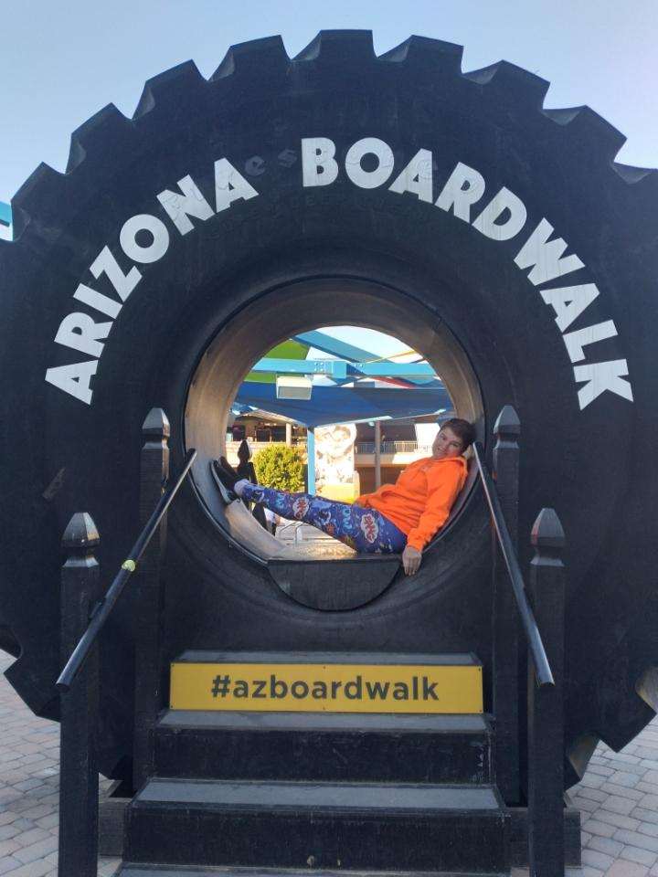 A person is sitting in the wheel of an arizona boardwalk.
