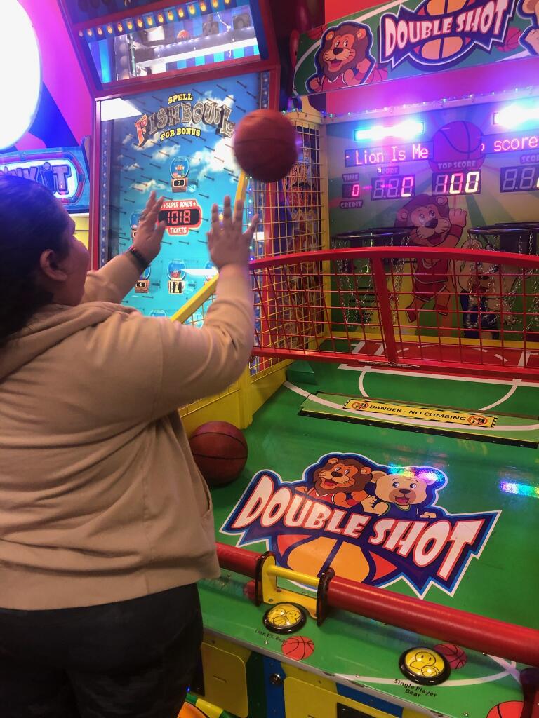 A woman playing basketball in an indoor game.