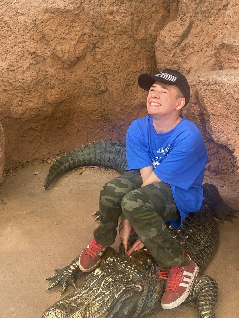 A man sitting on top of an alligator.