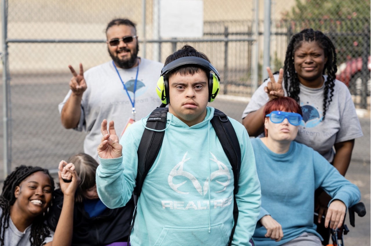 A group of people with headphones on and one person wearing headphones.